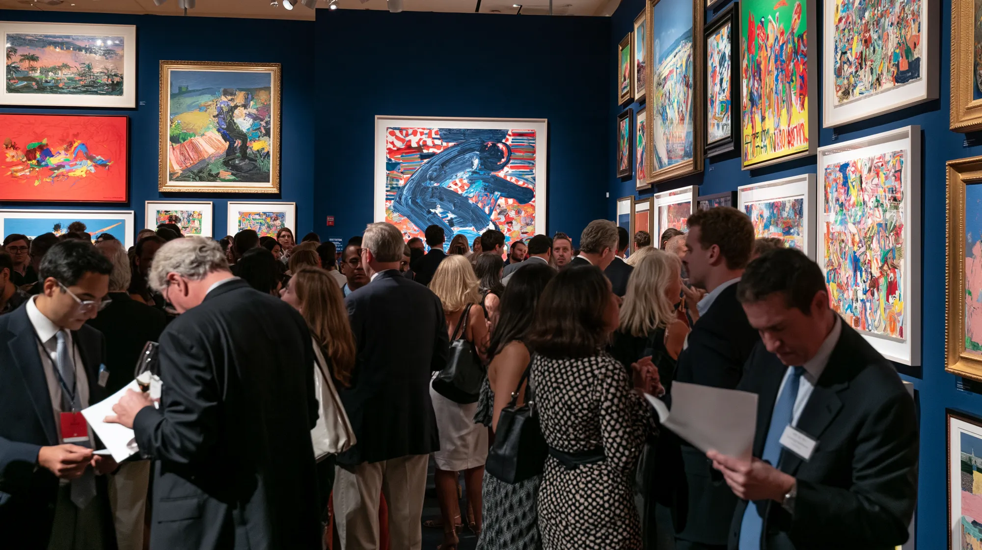 Visiteurs dans une galerie aux murs couverts de tableaux
