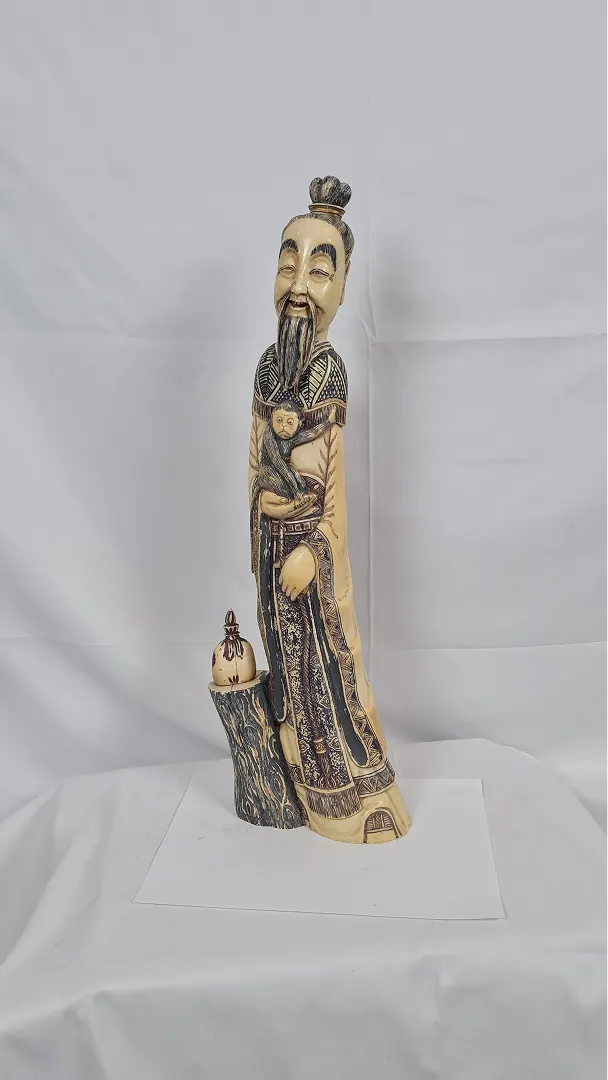 Sage rieur tenant un singe, appuyé sur un tronc